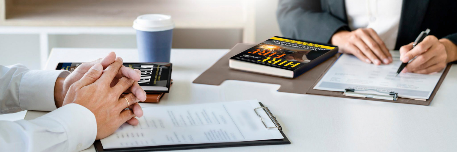 People sitting at a table interviwing with the books, Interview with Desire and Get Hired and Hire with Fire.